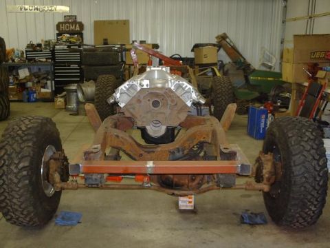 1978 Ford F-350 - A vehicle's chassis and engine are assembled in a workshop, surrounded by tools and equipment.
