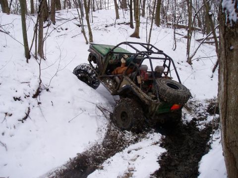 1992 Ford Bronco - An off-road vehicle navigates a challenging snowy and muddy terrain, demonstrating its off-road capabilities.