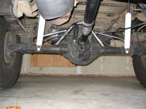1995 Ford Bronco - Undercarriage view of a vehicle's rear axle and suspension system, showing the differential and driveshaft.