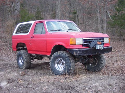 1983 Ford Bronco - Modified Ford Bronco with off-road upgrades parked in a natural setting.