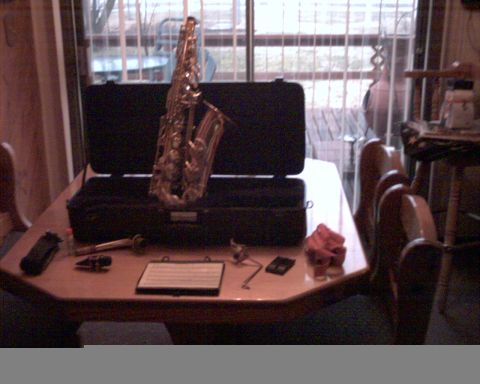 1990 Ford Bronco - A saxophone rests on its case on a table, accompanied by sheet music and various accessories.