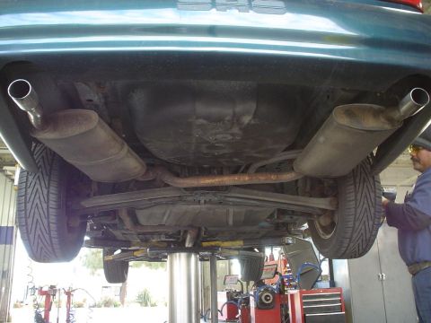 1993 Ford Taurus - Underside view of a car showing its dual exhaust system and rear suspension components.