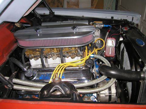 1966 Ford Fairlane - The engine bay of a red 1966 Ford Fairlane shows a V8 engine with dual carburetors and an MSD ignition box.