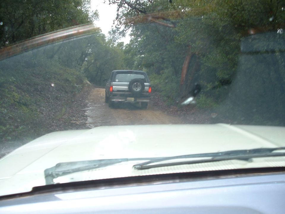 1991 Ford Bronco driving on a dirt road, seen from another vehicle