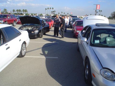1993 Ford Taurus - A silver sedan with a sunroof is parked in a lot with other vehicles.