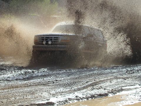 1993 Ford Bronco - This 1993 Ford Bronco navigates a muddy trail, kicking up a significant amount of spray.