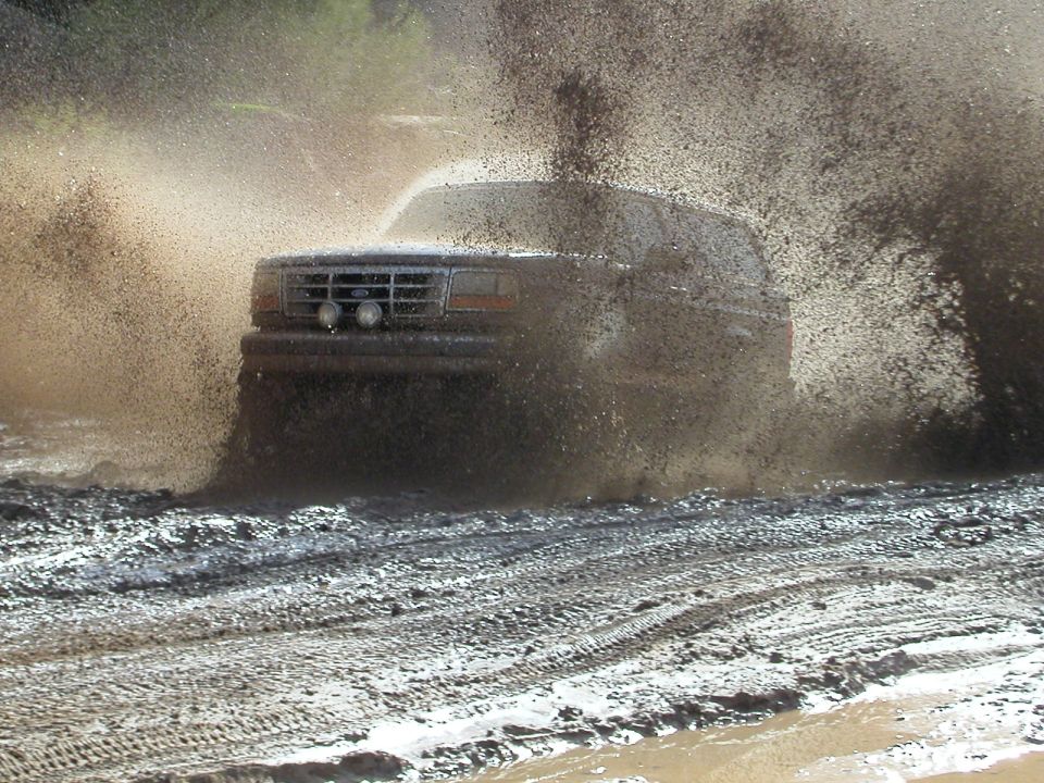 1993 Ford Bronco splashing through mud