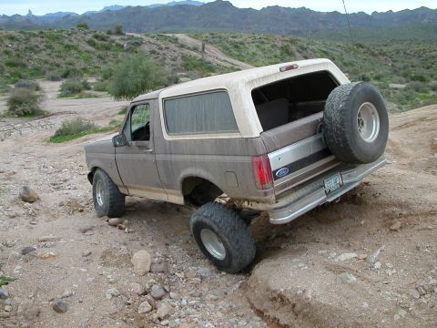 1993 Ford Bronco - Ford Bronco navigates challenging terrain in a desert landscape.