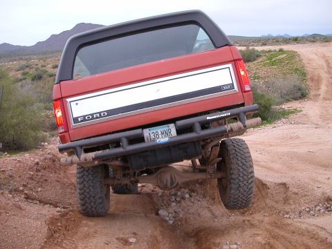 1993 Ford Bronco - This 1993 Ford Bronco is captured from the rear as it navigates a challenging dirt path.