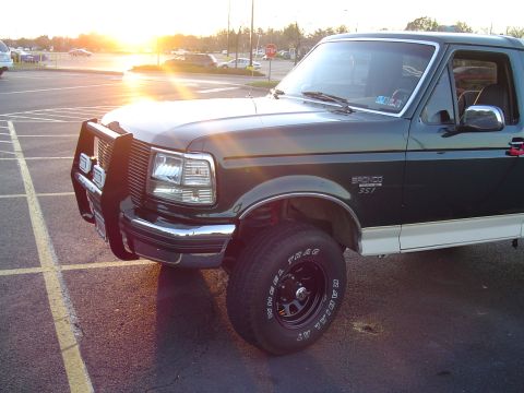 1993 Ford Bronco - A 1993 Ford Bronco is seen from the front-three-quarter angle in a parking lot during sunset.