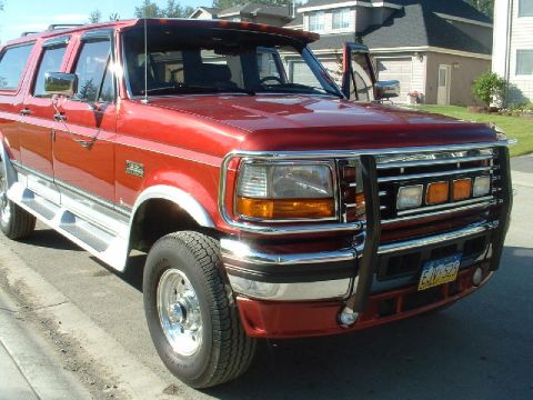 1996 Ford C-350 (Centurion Conversions) - This red pickup truck has a chrome grille guard and running boards.
