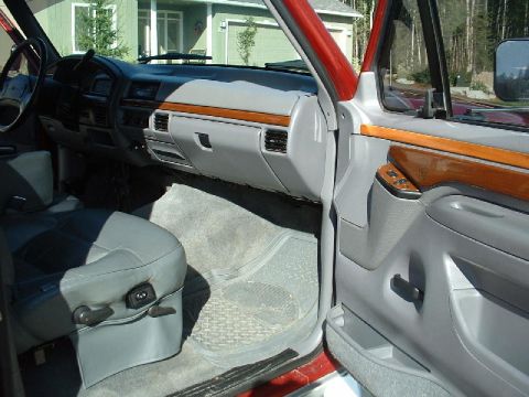 1996 Ford C-350 (Centurion Conversions) - The interior of a 1996 Ford C-350 Centurion Conversions features a gray dashboard with wood trim and a gray driver's seat.