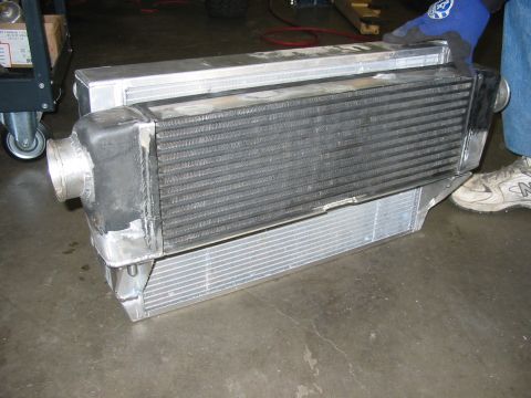 1993 Ford Taurus - A person holds an aluminum intercooler, a component used to cool air for an engine.