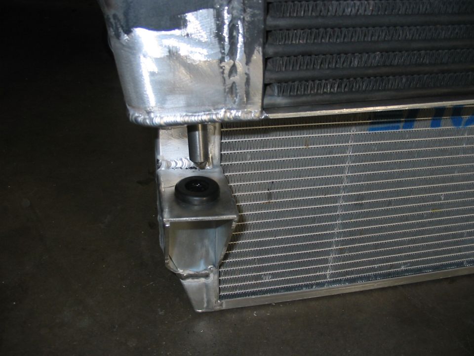 Radiator with custom aluminum mounting bracket and black rubber isolator