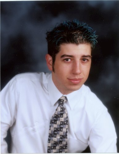 1993 Ford Probe - Portrait of a man with blue-tinted hair wearing a white shirt and a patterned tie, with a SuperMotors.net watermark.
