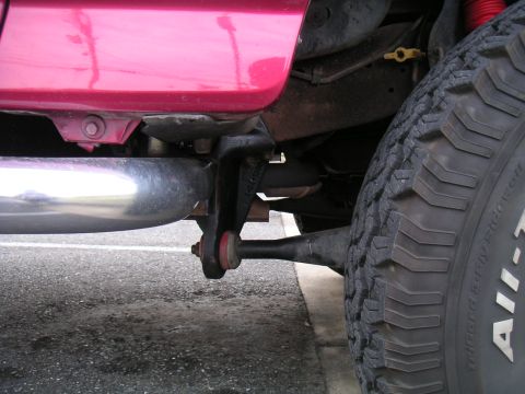 1994 Ford Bronco - This image focuses on the undercarriage of a vehicle, highlighting its suspension components and exhaust system.