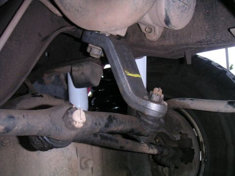 1994 Ford Bronco - Undercarriage view of a vehicle's suspension system, showing various metal parts and a tire.