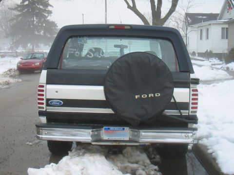 1992 Ford Bronco - This 1992 Ford Bronco is parked outside in the snow with a spare tire cover on the back.