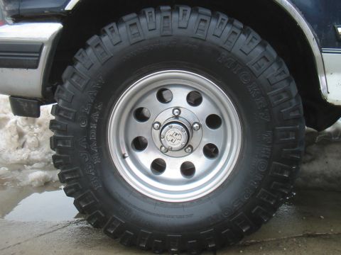 1992 Ford Bronco - Close-up of a Mickey Thompson Baja Claw Radial tire on a silver 5-hole wheel.