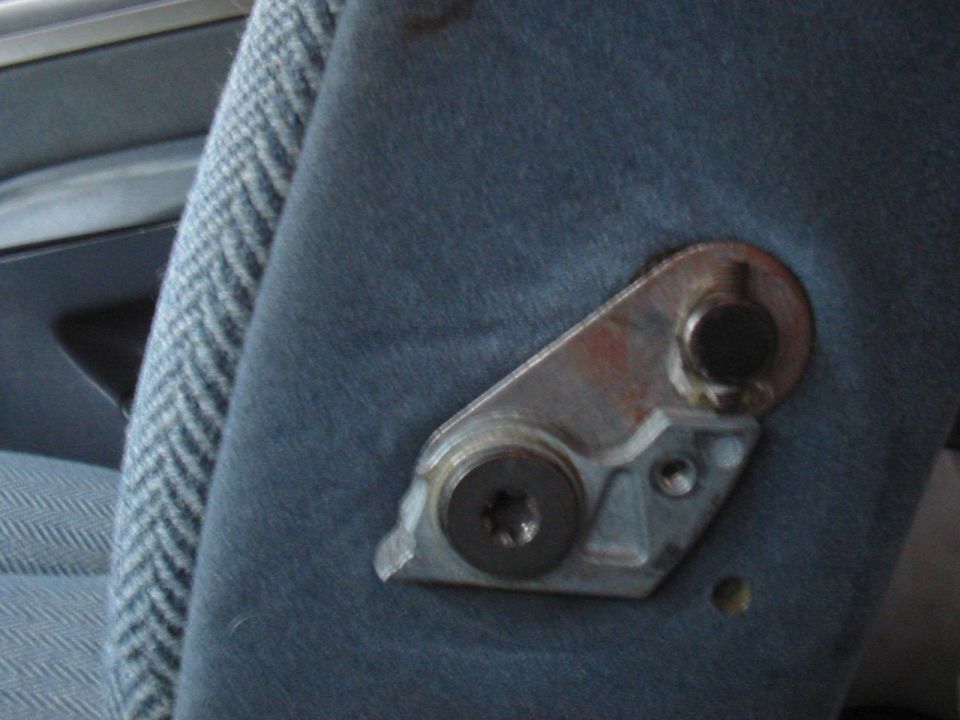 Close-up of a metal seat adjustment mechanism on blue fabric upholstery