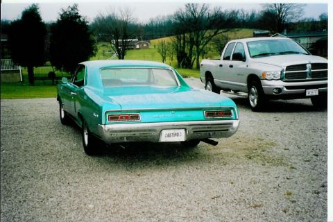 1967 Pontiac Lemans - Rear view of a turquoise 1967 Pontiac Lemans parked on a gravel driveway with a pickup truck.