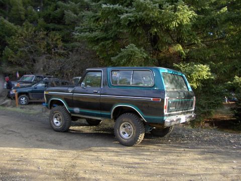 1978 Ford Bronco - This 1978 Ford Bronco is parked on a dirt road with trees in the background.