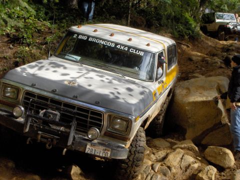 1978 Ford Bronco - This Ford Bronco navigates a challenging rocky terrain, with another vehicle visible further up the trail.