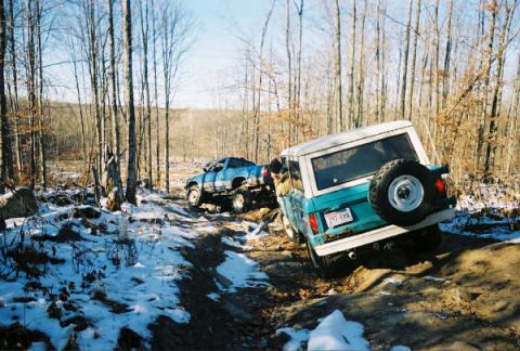 1977 Ford F-150 - Two trucks off-roading on a winter trail with snow on the ground.