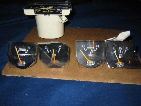 1985 Ford Bronco - A collection of automotive dashboard gauges, including a tachometer, fuel gauge, and temperature gauge, are displayed on a piece of cardboa…