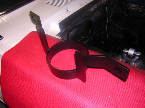 1992 Ford Crown Victoria - A black metal bracket with a circular clamp rests on a red cloth in the engine bay of a vehicle.