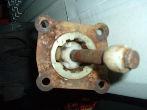 1989 Ford Escort - A close-up of a rusted metal part with a white plastic component and a metal rod is visible.