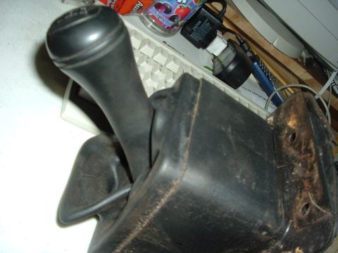 1989 Ford Escort - Close-up of a vehicle's gear shift knob and boot, with a keyboard and other items in the background.