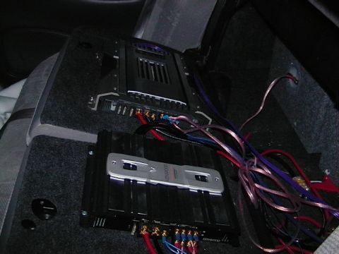 1999 Ford Taurus - Two car stereo amplifiers are installed and wired in the interior of a vehicle.