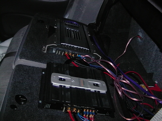 two car stereo amplifiers wired up in a car's interior