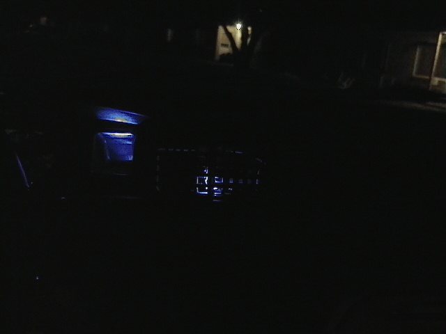 car interior with blue illuminated dashboard elements at night