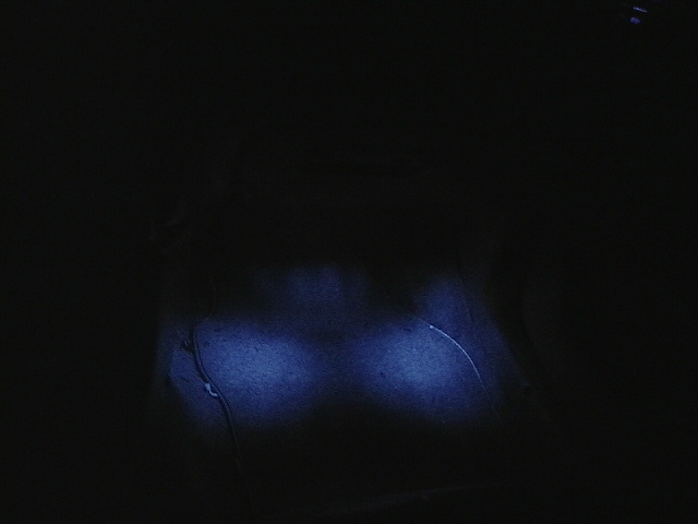 Dark interior with two illuminated blue lights and a wire
