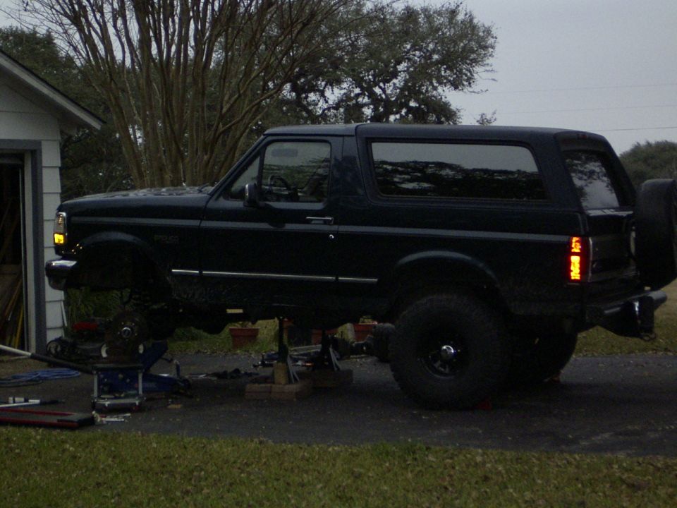 Dark blue 1995 Ford Bronco side view on jack stands with rear spare tire