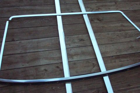 1985 Ford Crown Victoria LTD - Several chrome trim pieces are arranged on a wooden plank surface.