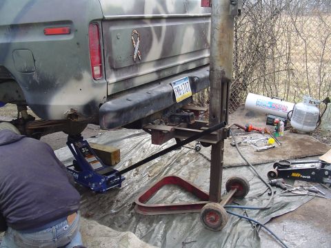 1990 Ford Bronco - Ford truck undergoing repairs with a jack and various tools laid out.