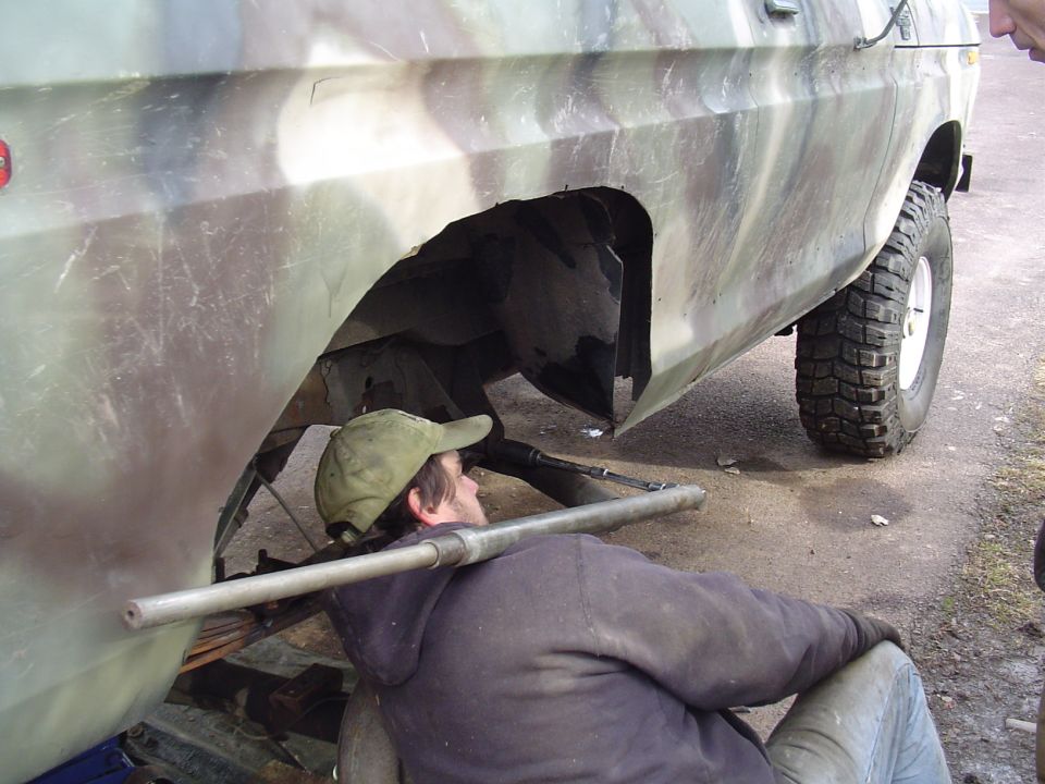 Camouflage SUV side view, undergoing repair. 1990 Ford Bronco