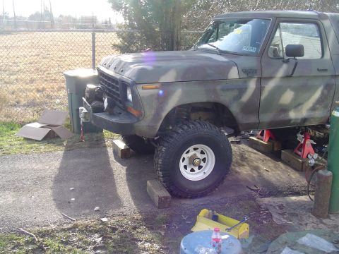 1990 Ford Bronco - This lifted Ford Bronco is undergoing maintenance, supported by red jack stands.