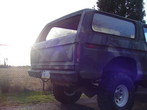 1990 Ford Bronco - Rear view of a camouflaged Ford Bronco with a lifted suspension and off-road tires.