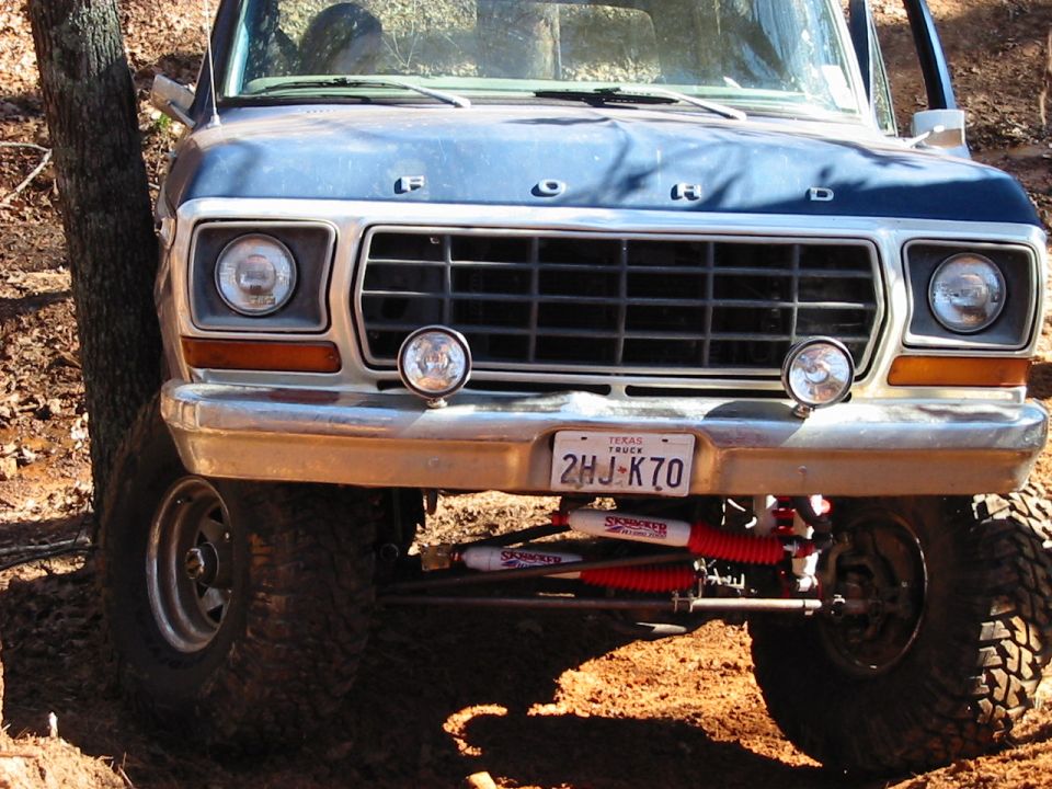 1978 Ford Bronco front grille, headlights, and Texas license plate 2HJ-K70. Off-road suspension with red shocks visible