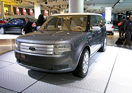 1973 Ford Ranchero - A gray SUV concept vehicle is displayed at an auto show, with other cars and people in the background.