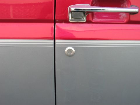 1995 Ford Bronco - Close-up of the side door on a 1995 Ford Bronco, showing its two-tone paint scheme.