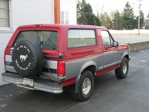 1995 Ford Bronco - The rear view of a two-tone Ford Bronco, showing its spare tire and license plate.