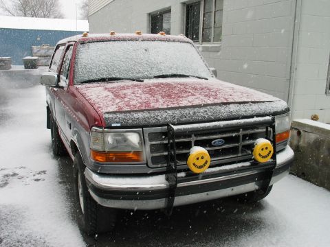 1995 Ford Bronco - Red 1995 Ford Bronco parked outside during a snowfall.