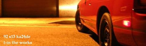 1992 Nissan 240SX - A red car is parked in front of a garage door at night.