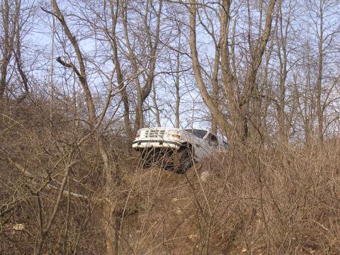 1995 Jeep Cherokee - This 1995 Jeep Cherokee is navigating a challenging off-road trail through dense trees.