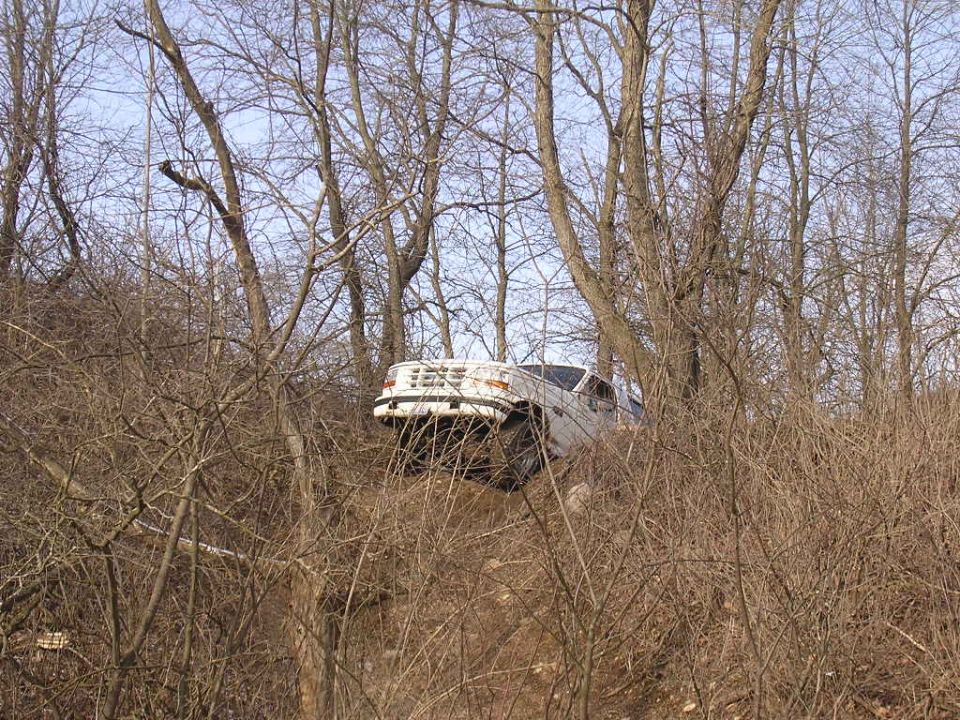 1995 Jeep Cherokee driving on a steep, wooded incline